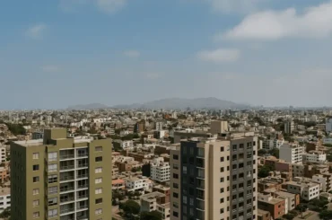 Vista panorámica de Lima con edificios residenciales modernos en primer plano y la ciudad extendiéndose hacia las colinas al fondo, representando distritos emergentes.
