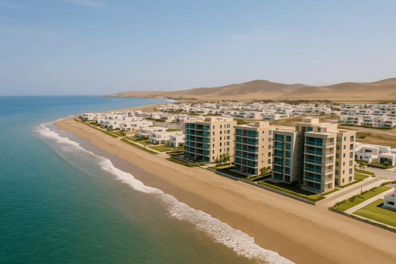 Vista aérea de modernos departamentos frente al mar en la costa peruana, con arquitectura contemporánea y amplias áreas verdes, reflejando proyectos inmobiliarios de playa en Perú.