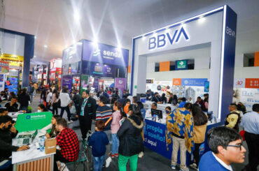 Personas recibiendo asesoría y comparando proyectos de departamentos en una feria de Nexo Inmobiliario en Lima.