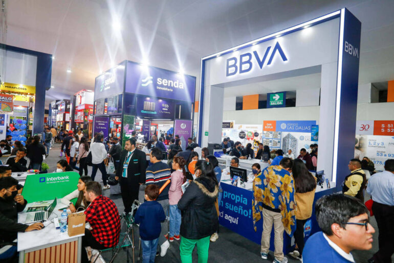 Personas recibiendo asesoría y comparando proyectos de departamentos en una feria de Nexo Inmobiliario en Lima.