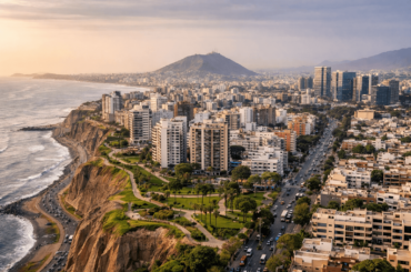 Vista aérea de Lima en abril con edificios residenciales frente al mar en Miraflores, mostrando distritos con alta demanda inmobiliaria para compra de departamentos en Perú. distritos