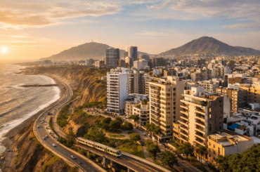 Vista panorámica de Lima con edificios residenciales modernos, costa del Pacífico y vías de transporte, representando una ubicación estratégica para vivir cerca al trabajo o estudio.